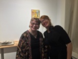 Elizabeth M. Willey and Ruth Reese, artist, and owner of Reese Gallery, in front of "Pocket Full of Posies", which is encaustic mixed media on panel.